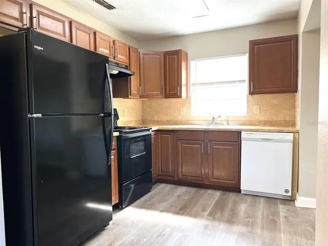 a kitchen with a refrigerator and a sink