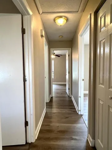 a view of a hallway with wooden floor and staircase