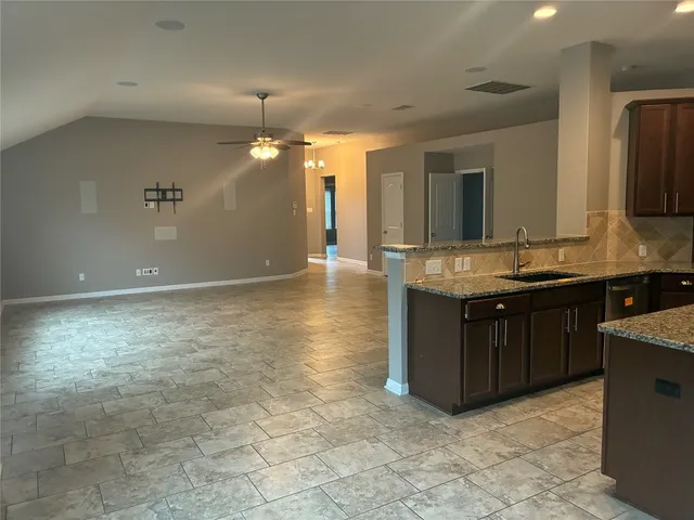 a kitchen with granite countertop a sink and a stove