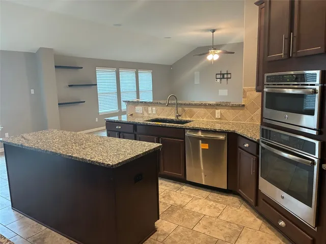 a kitchen with stainless steel appliances granite countertop a sink stove and cabinets