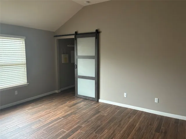 an empty room with wooden floor and closet