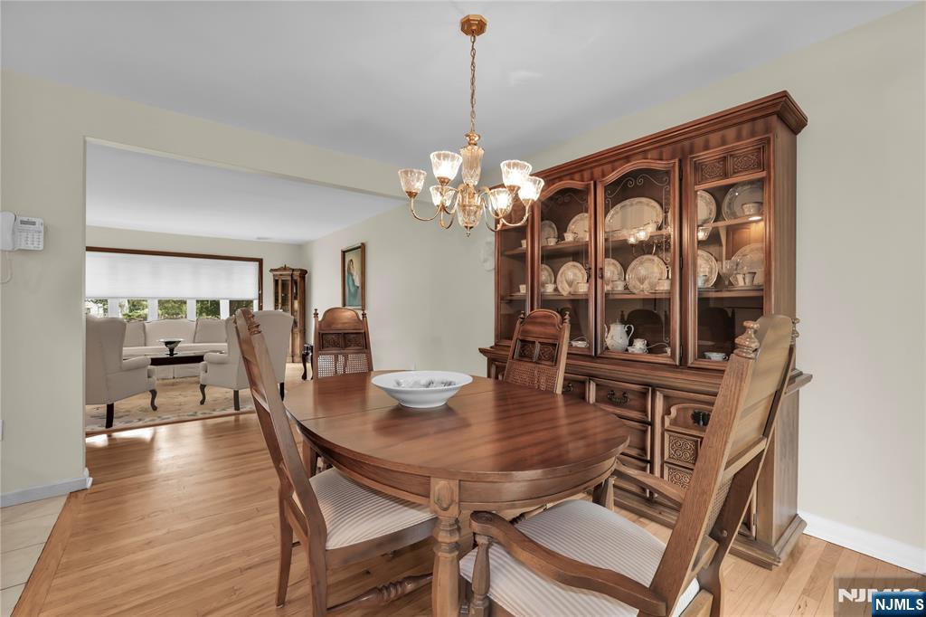 23 Ridge Court Cedar Grove, NJ 07009 - Photo 11 of 37 a dining room with furniture a chandelier and wooden floor