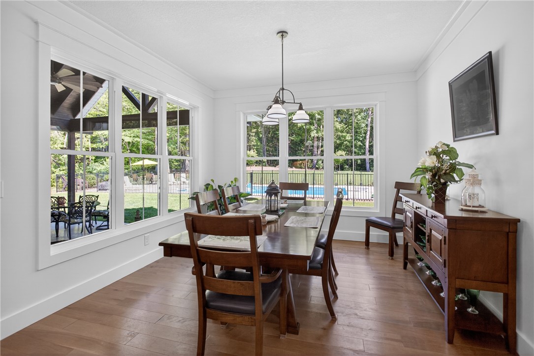 921 Falling Waters Lane Seneca, SC 29672 - Photo 17 of 46 A well-lit dining area featuring rich hardwood floors and picturesque views of the fenced backyard pool and patio.