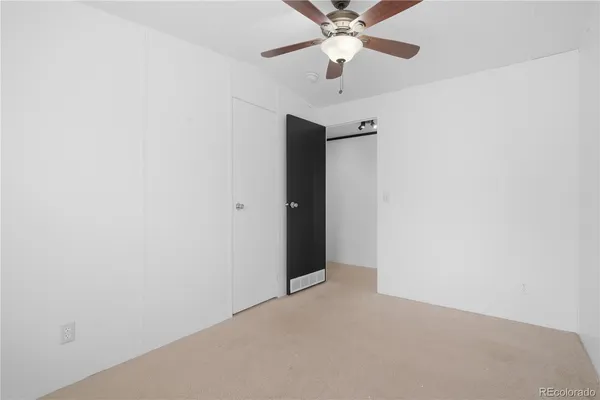 an empty room with a ceiling fan and a fan