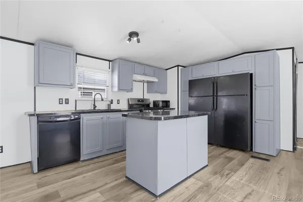 a kitchen with stainless steel appliances granite countertop a refrigerator and a stove