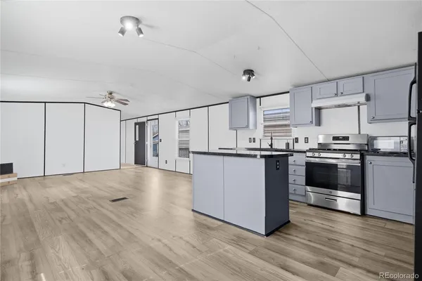 a kitchen with granite countertop a refrigerator and a stove top oven