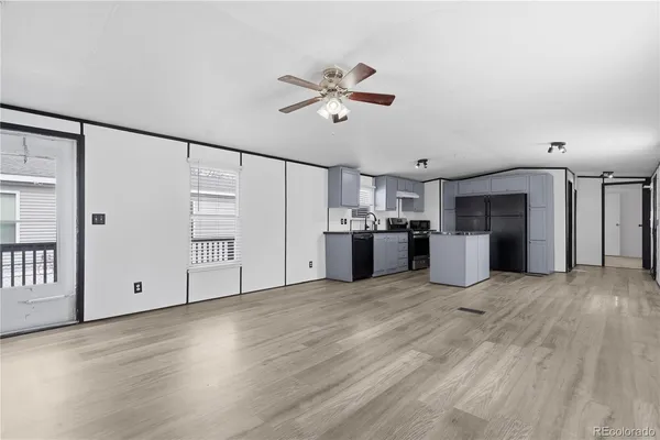 a view of a kitchen with wooden floor and a ceiling fan
