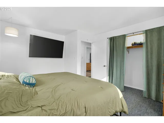 a bedroom with a bed and a flat screen tv