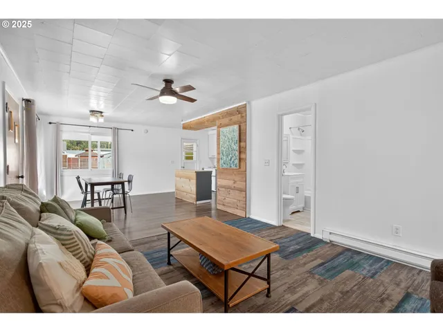 a living room with furniture a ceiling fan and a rug