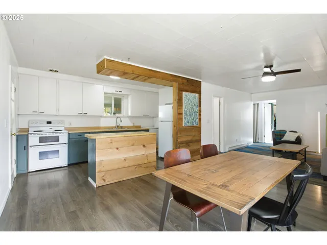 a kitchen with a table a sink cabinets and stainless steel appliances