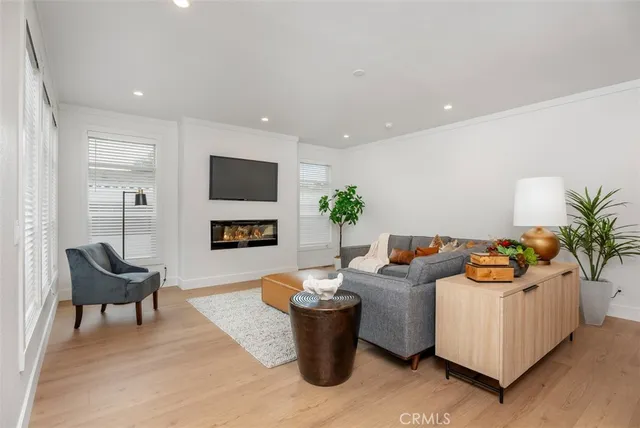 a kitchen with stainless steel appliances granite countertop a stove a refrigerator a kitchen island a sink cabinets and wooden floor