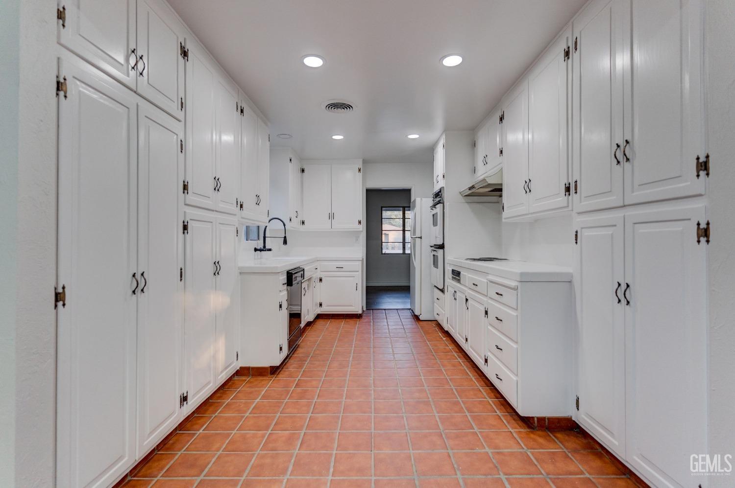 Undisclosed Address Bakersfield, CA 93309 - Photo 11 of 23 a large white kitchen with stainless steel appliances granite countertop a sink and cabinets