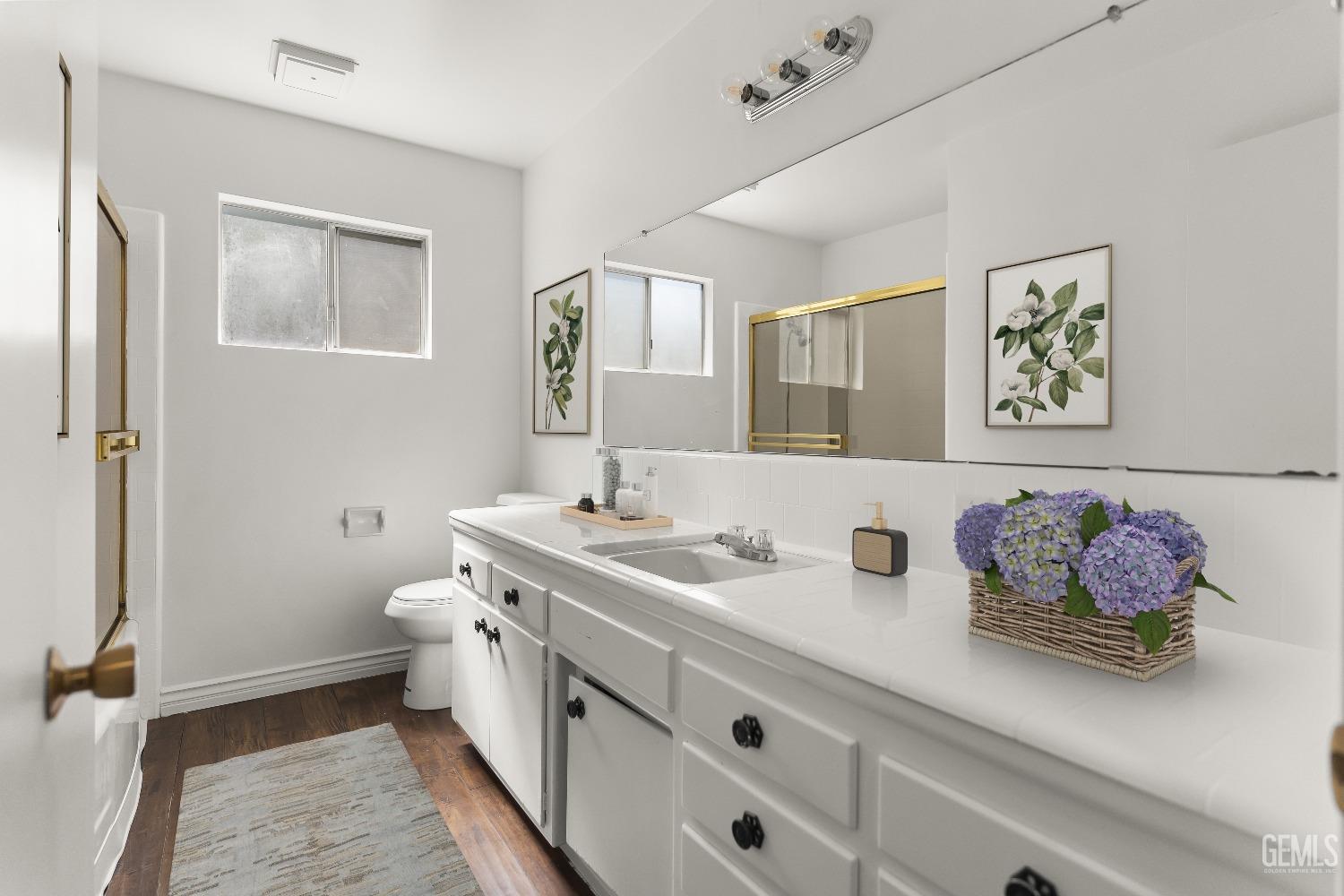 Undisclosed Address Bakersfield, CA 93309 - Photo 13 of 23 a bathroom with double vanity sinks a toilet and a mirror