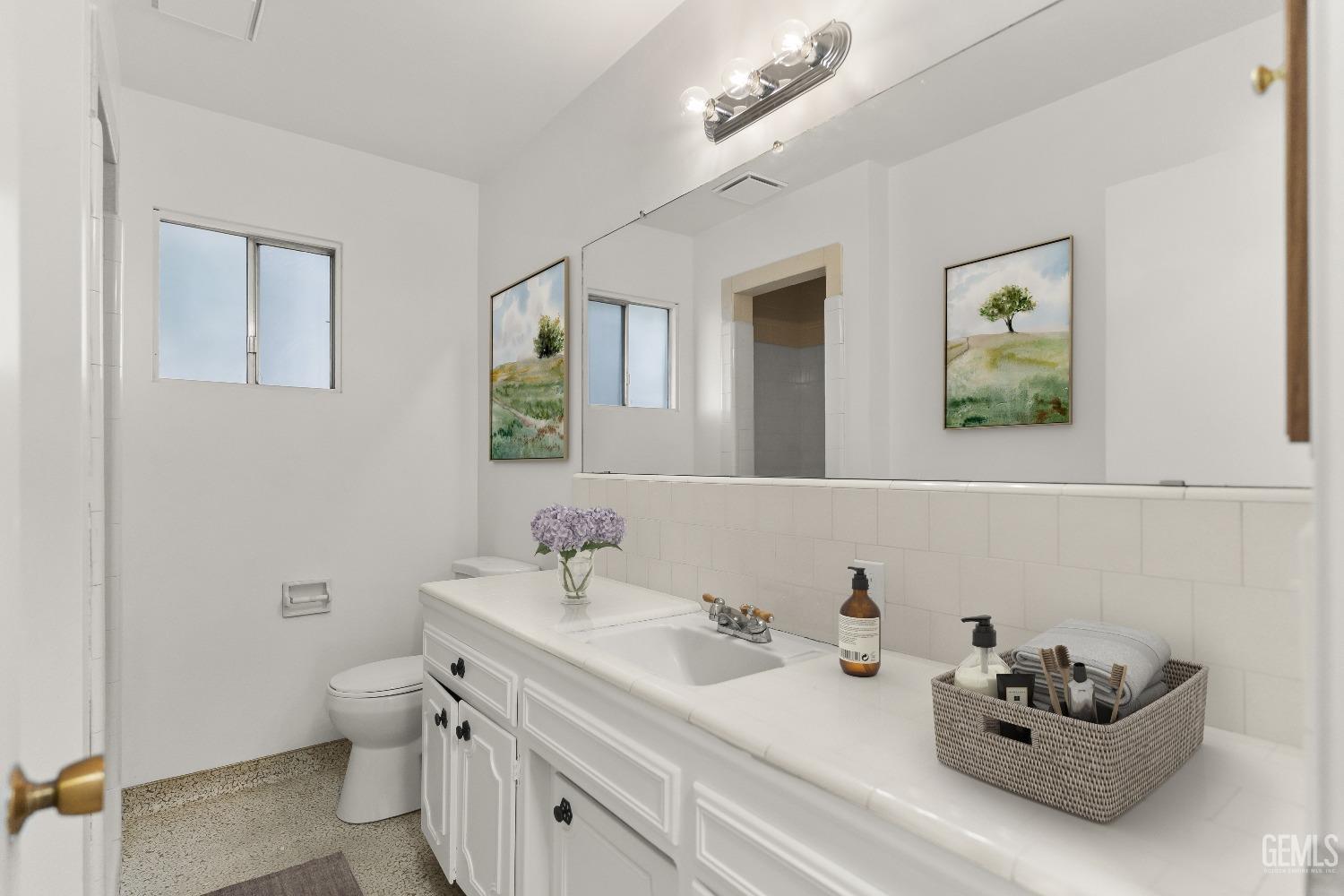 Undisclosed Address Bakersfield, CA 93309 - Photo 18 of 23 a bathroom with a double vanity sink mirror and toilet