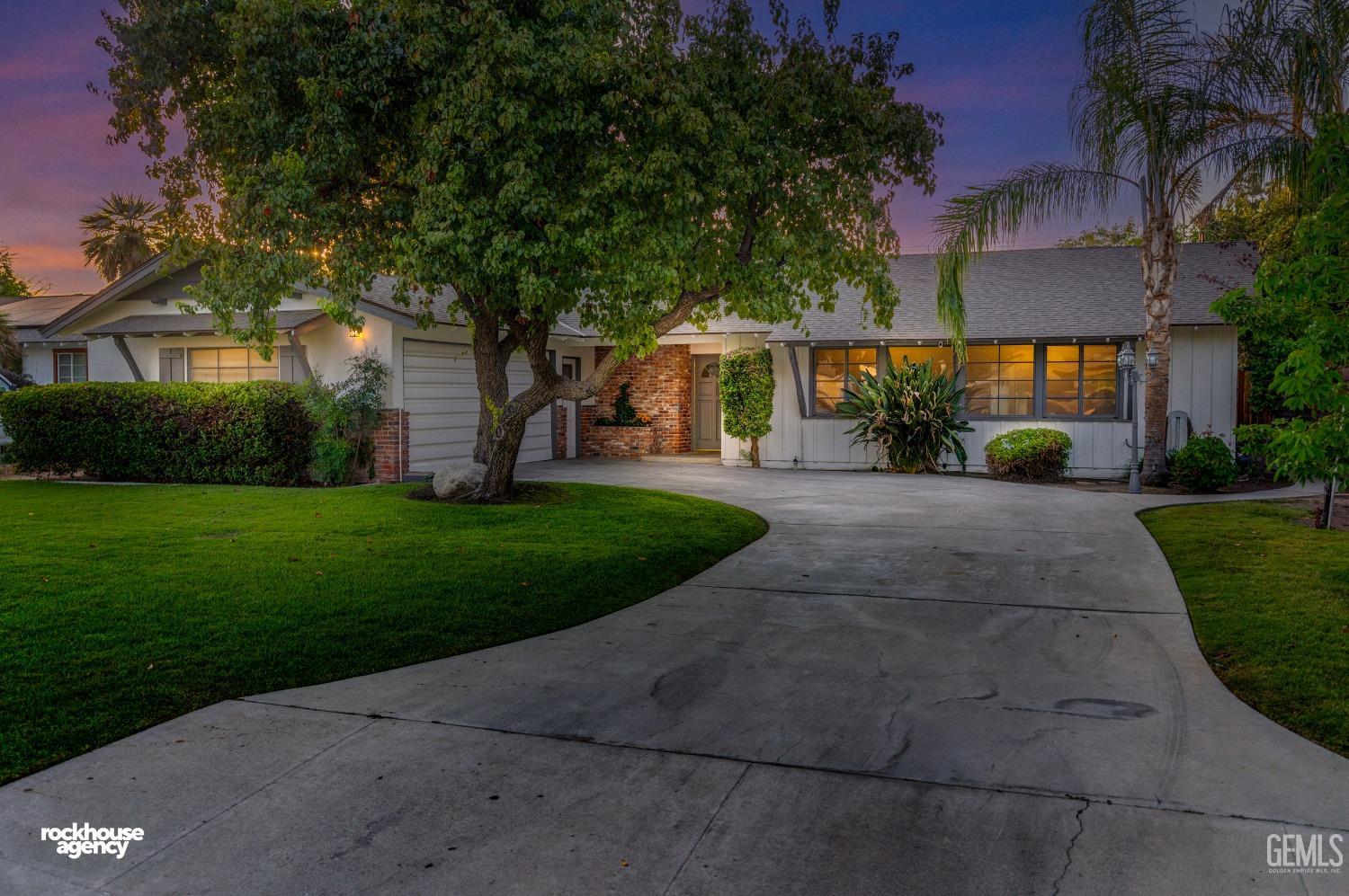Undisclosed Address Bakersfield, CA 93309 - Photo 2 of 23 a front view of a house with a yard and trees