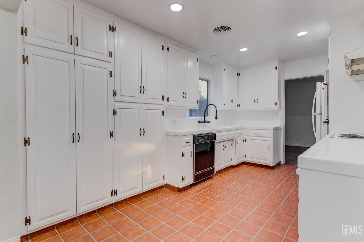 Undisclosed Address Bakersfield, CA 93309 - Photo 9 of 23 a kitchen with white cabinets and white appliances