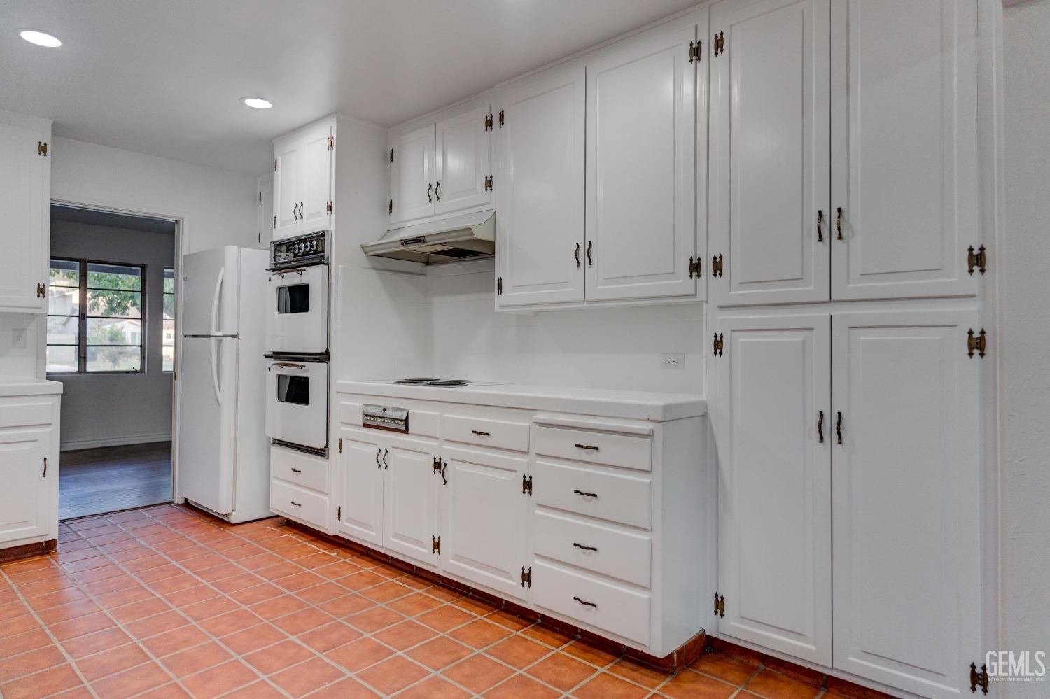 Undisclosed Address Bakersfield, CA 93309 - Photo 10 of 23 a kitchen with white cabinets and appliances