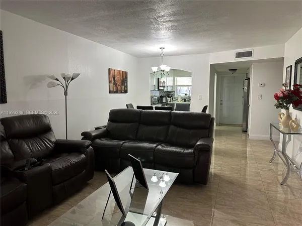a living room with furniture kitchen view and a window