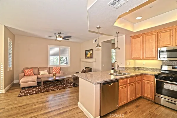 a kitchen with granite countertop a sink stainless steel appliances and cabinets