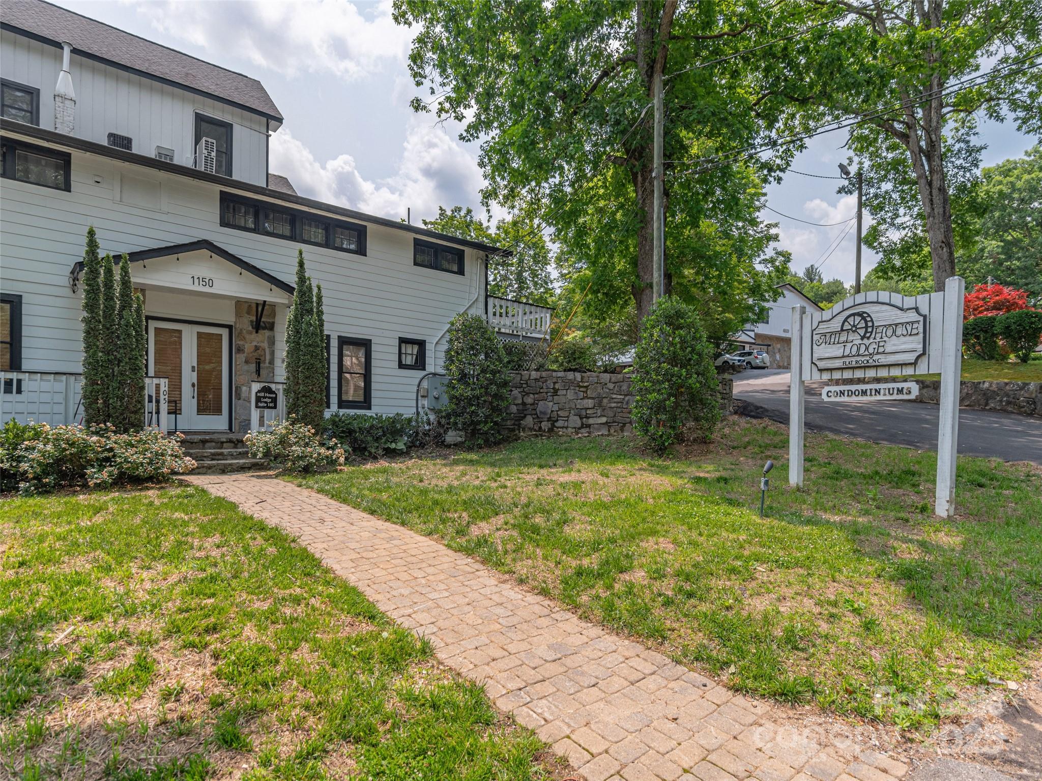 1150 West Blue Ridge Road, Unit 103 Flat Rock, NC 28731 - Photo 14 of 27 a front view of a house with garden