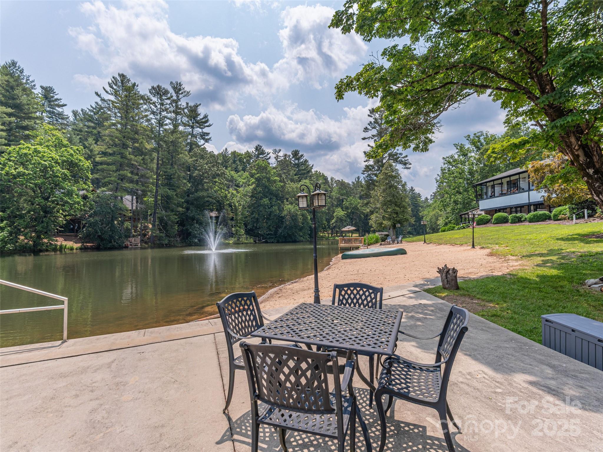 1150 West Blue Ridge Road, Unit 103 Flat Rock, NC 28731 - Photo 20 of 27 a view of a lake with table and chairs