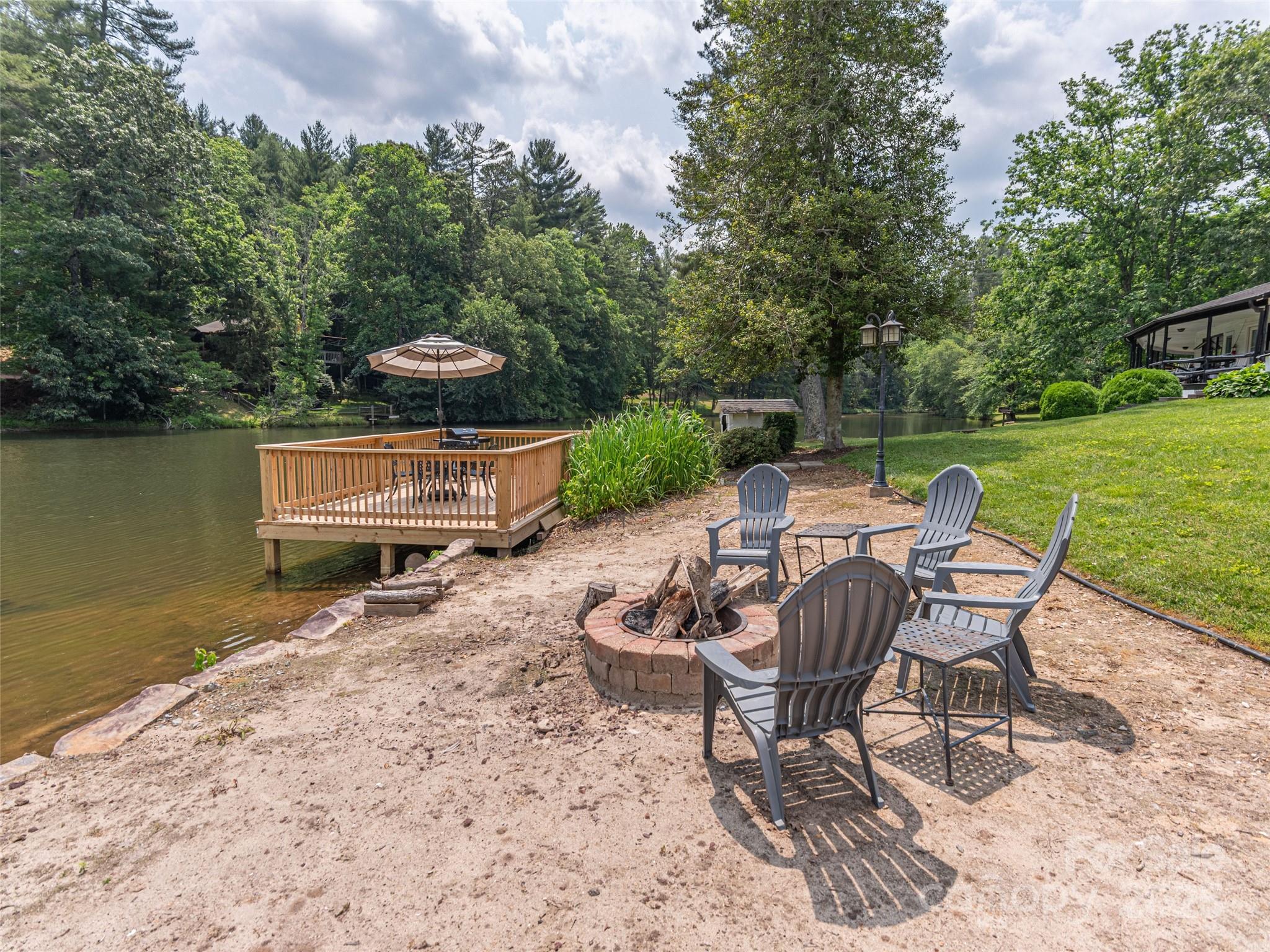 1150 West Blue Ridge Road, Unit 103 Flat Rock, NC 28731 - Photo 22 of 27 a patio with water view fountain and a fire pit