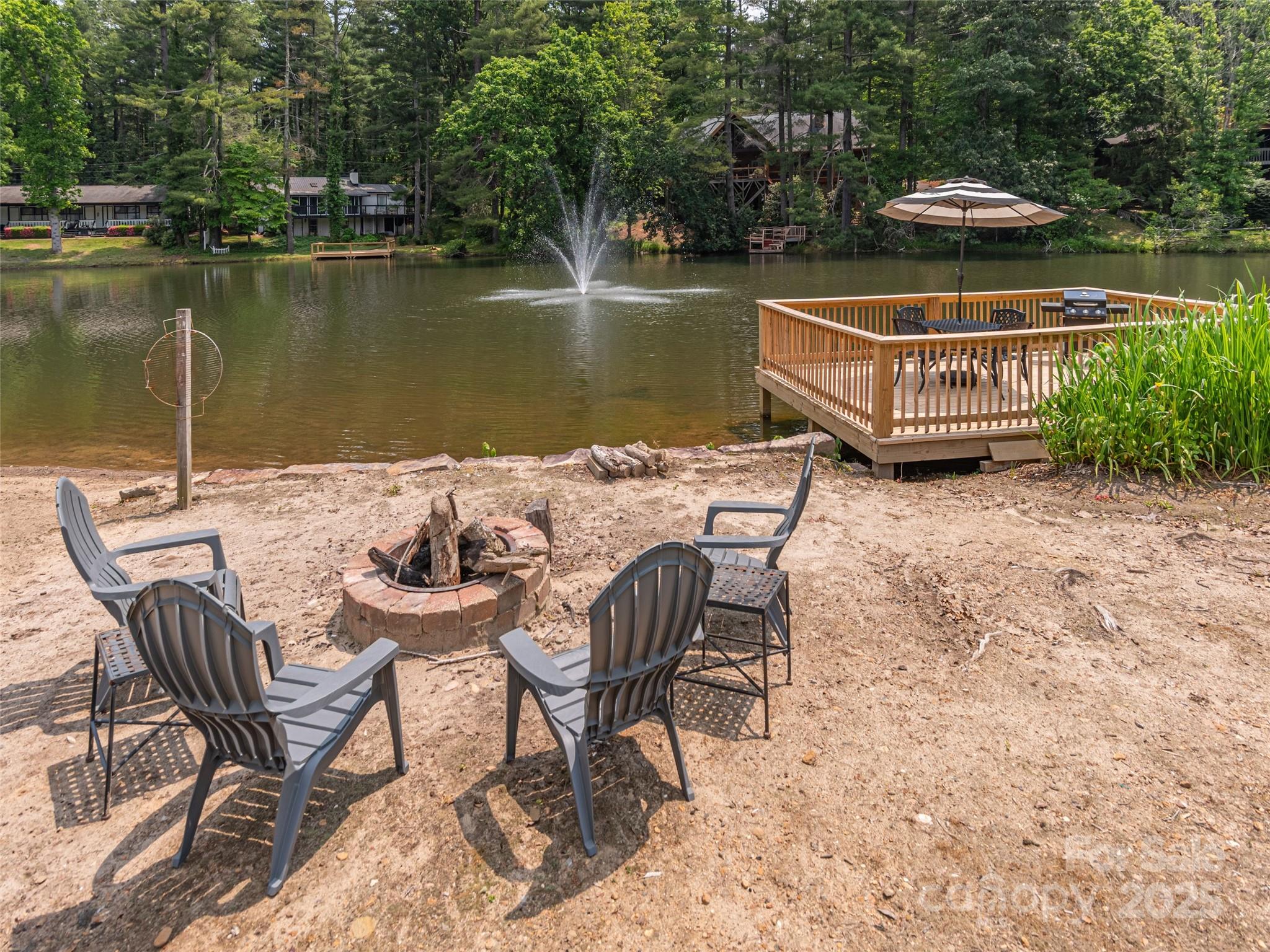 1150 West Blue Ridge Road, Unit 103 Flat Rock, NC 28731 - Photo 23 of 27 a view of a lake with table and chairs