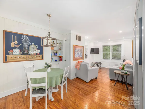 a living room with furniture dining table and a wooden floor