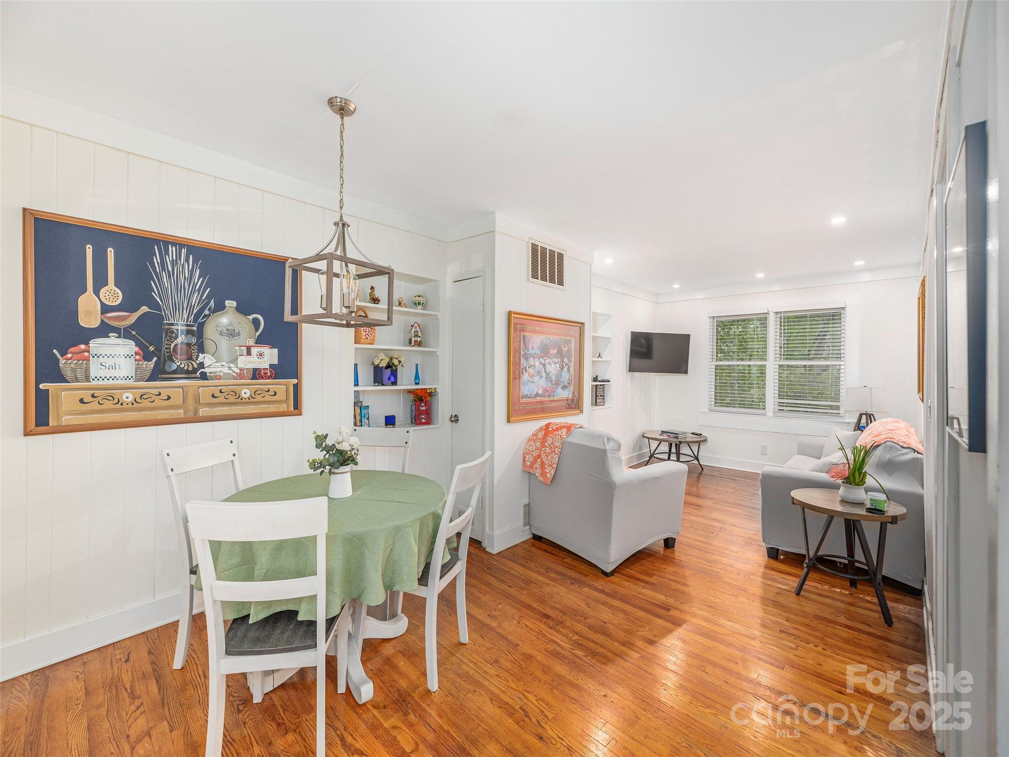 1150 West Blue Ridge Road, Unit 103 Flat Rock, NC 28731 - Photo 4 of 27 a living room with furniture dining table and a wooden floor
