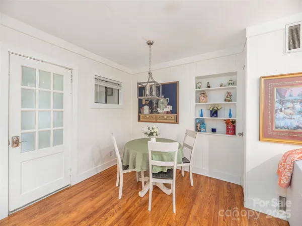 a dining room with furniture a window and wooden floor