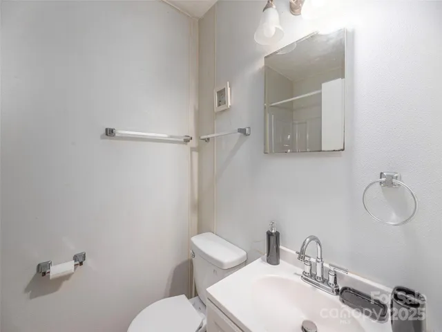 a bathroom with a sink mirror and toilet