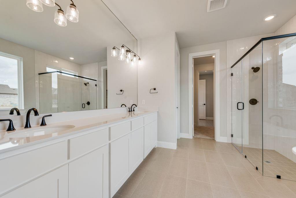 1259 Calebria Way Fate, TX 75087 - Photo 16 of 38 a bathroom with a double vanity sink mirror and shower
