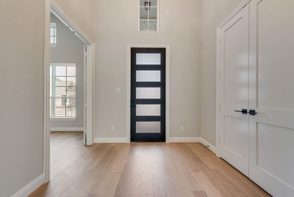 1259 Calebria Way Fate, TX 75087 - Photo 3 of 38 an empty room with wooden floor and cabinet