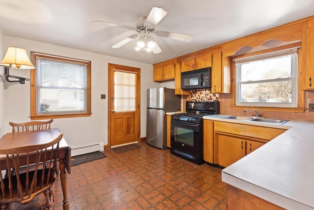 70 Charme Road Billerica, MA 01821 - Photo 10 of 29 a kitchen with stainless steel appliances granite countertop a stove a sink dishwasher a refrigerator with a dining table and chairs with wooden floor