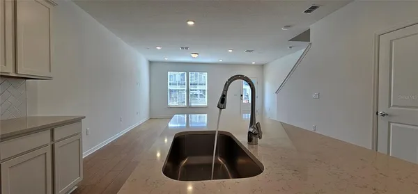 a view of a kitchen with wooden floor and electronic appliances
