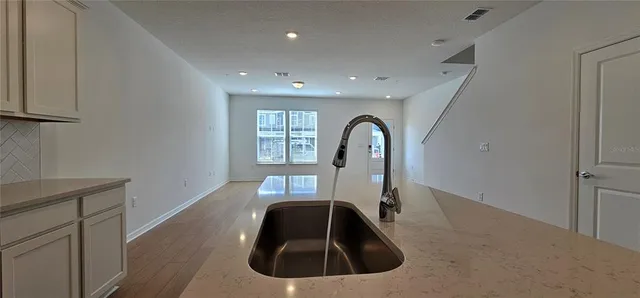 a view of a kitchen with wooden floor and electronic appliances