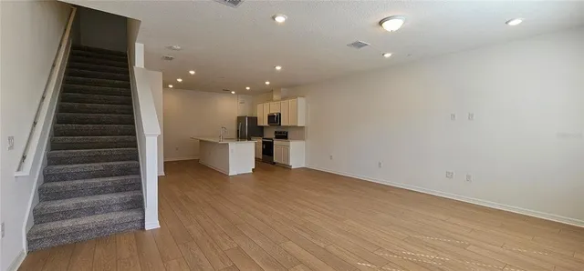 wooden floor in an empty room with a kitchen