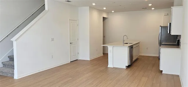 a view of a kitchen with a sink and wooden floor