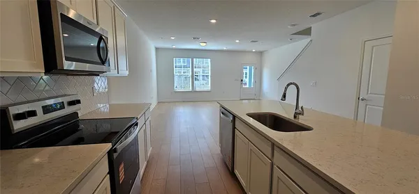 a kitchen with stainless steel appliances granite countertop a sink a stove microwave and refrigerator