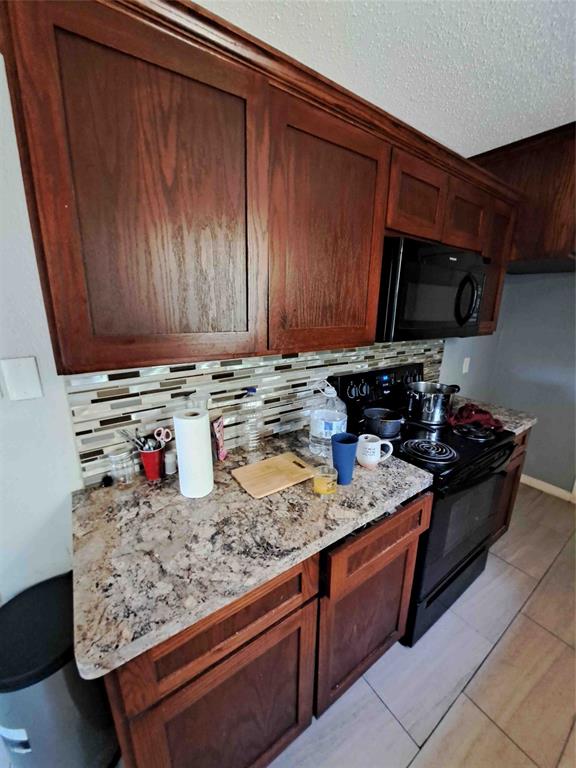321 Christie Avenue Everman, TX 76140 - Photo 5 of 8 a kitchen with stainless steel appliances granite countertop a stove and a sink