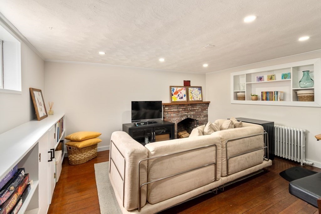 115 Bright Road Belmont, MA 02478 - Photo 19 of 22 a living room with furniture a fireplace and a flat screen tv