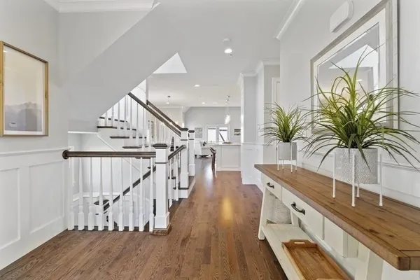 a view of hall with wooden floor and a potted plant