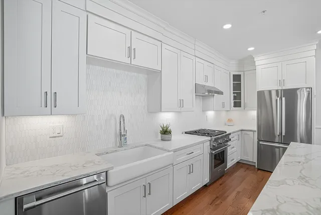 a kitchen with stainless steel appliances granite countertop a sink stove and refrigerator