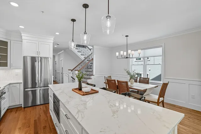 a view of a dining room and livingroom with furniture wooden floor a chandelier