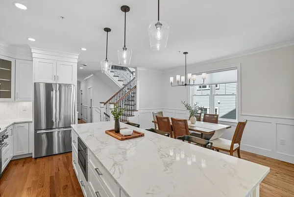 a view of a dining room and livingroom with furniture wooden floor a chandelier