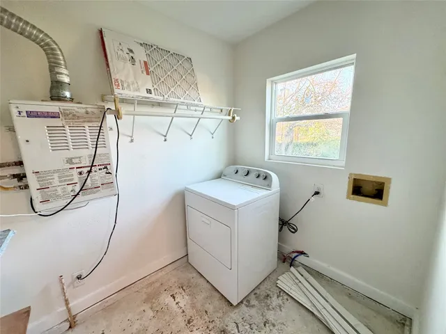 a utility room with closet and windows