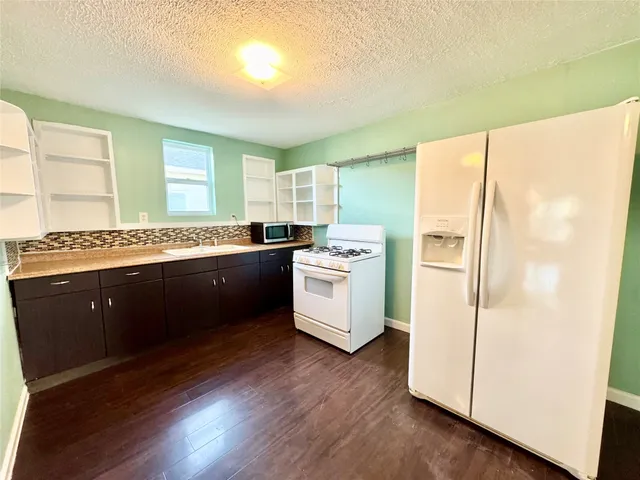 a kitchen with a refrigerator sink and cabinets