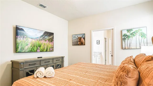 a bedroom with a bed and a flat screen tv