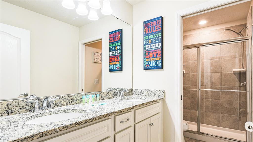 7219 Oakmoss Loop Davenport, FL 33837 - Photo 30 of 54 a bathroom with a granite countertop sink and a mirror