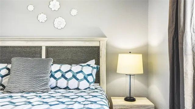 a large bed sitting in a bedroom next to a window